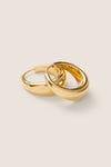 Gold Andrea Earrings: Classic, chunky yellow-gold huggie hoops with a tubular shape and hinge closure; an effortless, high-end touch for any outfit.