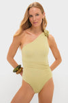 Model in an effortless, high-end Leek Green Ecos One Piece swimsuit, featuring classic one-shoulder design, floral detail, asymmetric back, and gentle side ruching, embodying fun elegance.