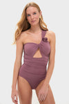 Woman models the Acai Rodriguez One Piece, a classic, high-end swimsuit with an effortless single-shoulder design, a fun rosette detail, and elegant waist ruching.