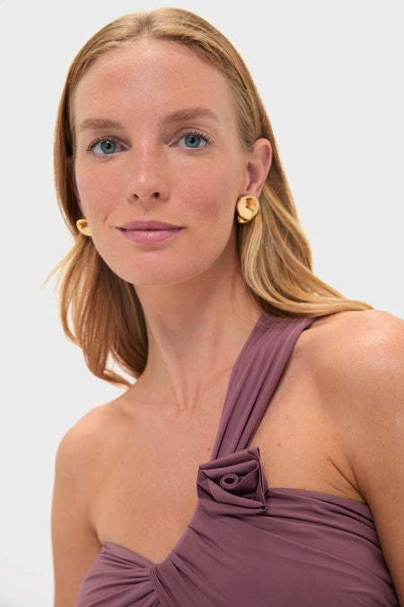Woman wearing the Acai Rodriguez One Piece, a classic and effortless mauve-purple top with a rose-shaped fold, paired with simple gold disc earrings for a high-end look.