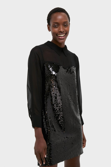 Smiling person wearing the Black Sequin Josie Dress: a classic, high-end piece with a sheer, long-sleeved top and an effortlessly fun, sequin-embellished body.