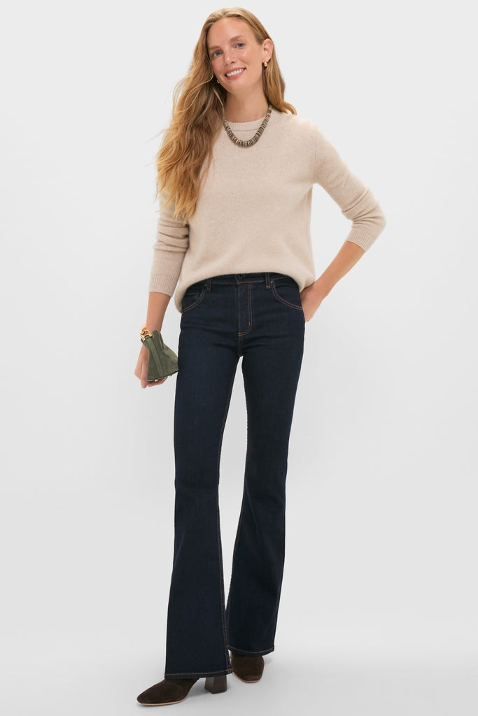Model wearing classic Indigo Resin Bond Street Jean with a flared silhouette, paired with a soft beige sweater and suede ankle boots, exuding an effortless, high-end style.