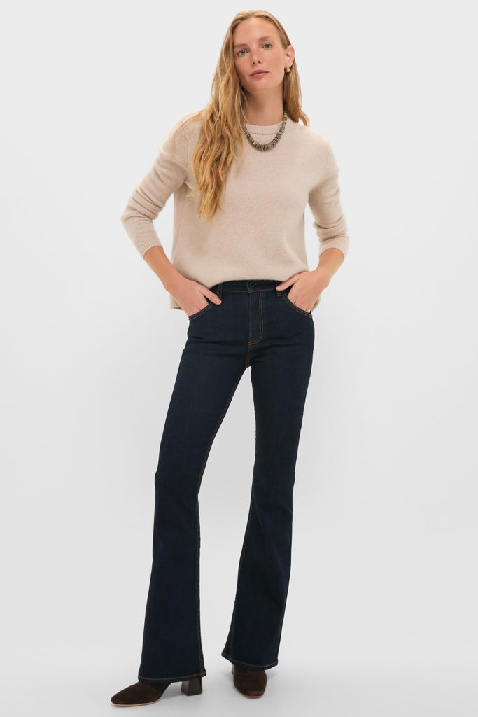 Person wearing Indigo Resin Bond Street Jean with a subtle flare, paired with a light beige sweater and metallic accessories, exuding classic, effortless high-end style.