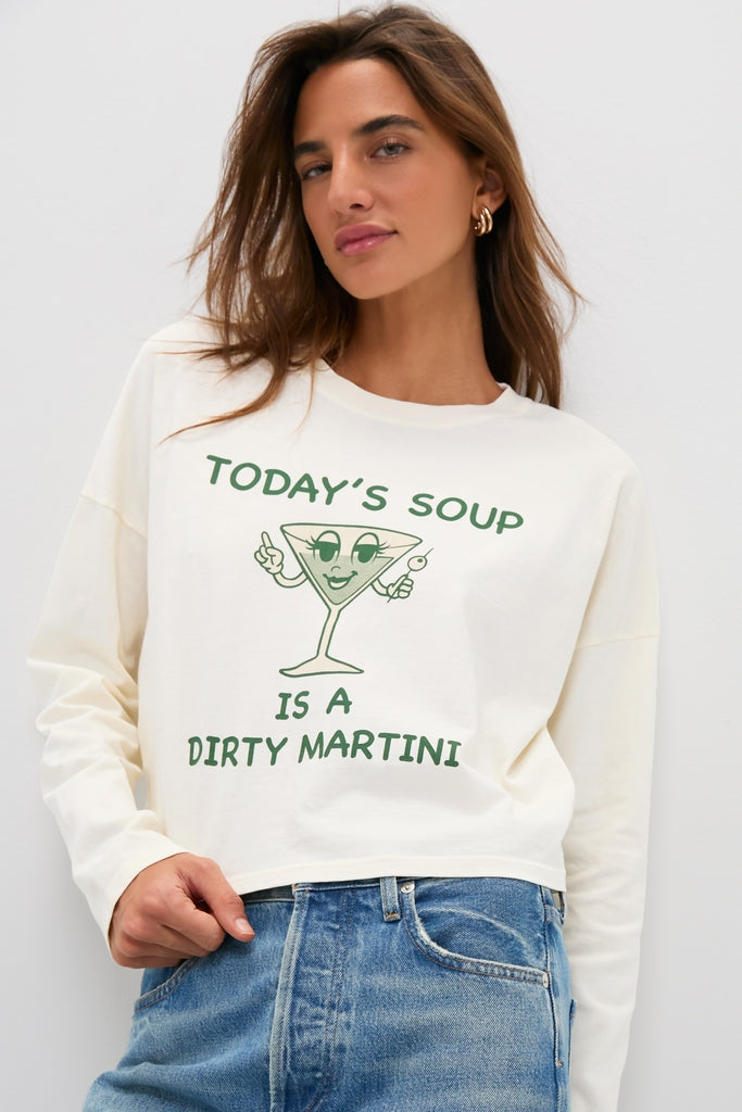 Person wearing the classic Martini Soup Crop Long Sleeve Tee, featuring a fun cartoon martini design. Effortless style paired with high-end light-wash jeans.