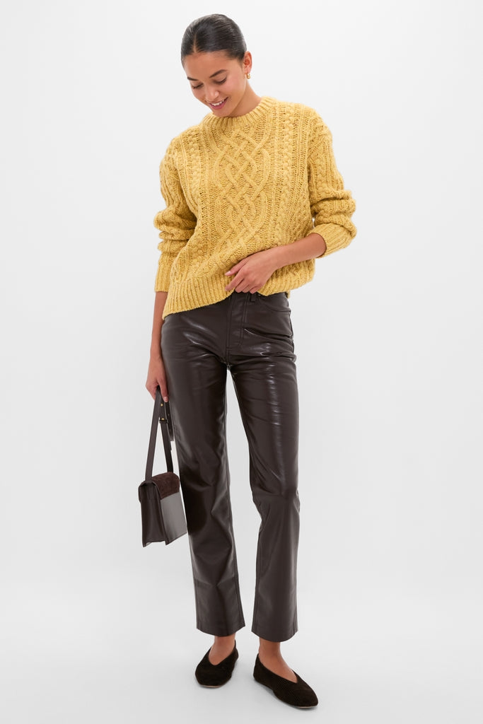 Woman wearing the classic Sunflower Madelyn Sweater tucked into high-end dark brown trousers, creating an effortless, fun look with a structured bag and loafers.