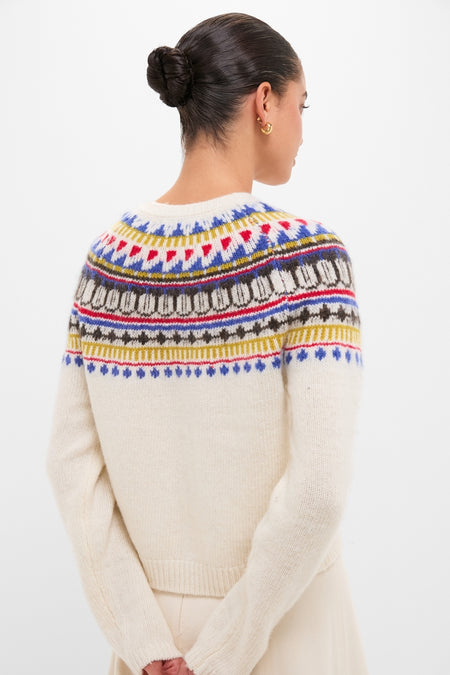 Model wearing the classic White Amina Fairisle Sweater, featuring an effortless multicolored yoke pattern, paired with a neat bun and gold hoop earring for a fun, high-end look.