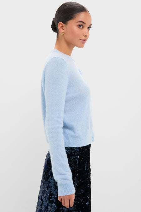 Young woman models the Ice Blue Cashmere Riley Cardigan, combining classic elegance with effortless style, paired with a high-end, fun navy sequined skirt.