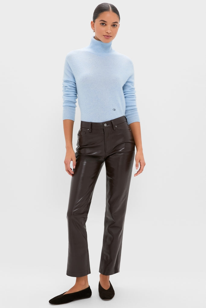 Young woman models the Ice Blue Cashmere Turtleneck Sweater, styled with high-waisted black leather pants and black flats, embodying a classic, effortless, and high-end look.