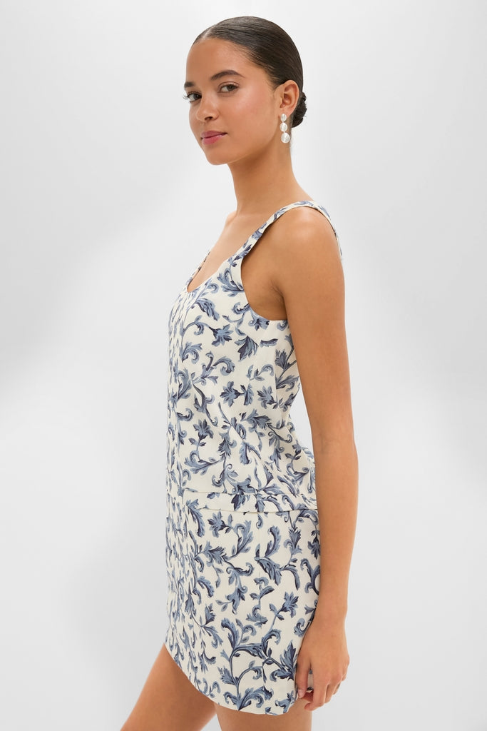 Model in profile wearing a classic Blue Baroque Rue Shift Mini Dress with effortless scoop neckline, pleats, and hidden pockets, exuding high-end fun and sophistication.