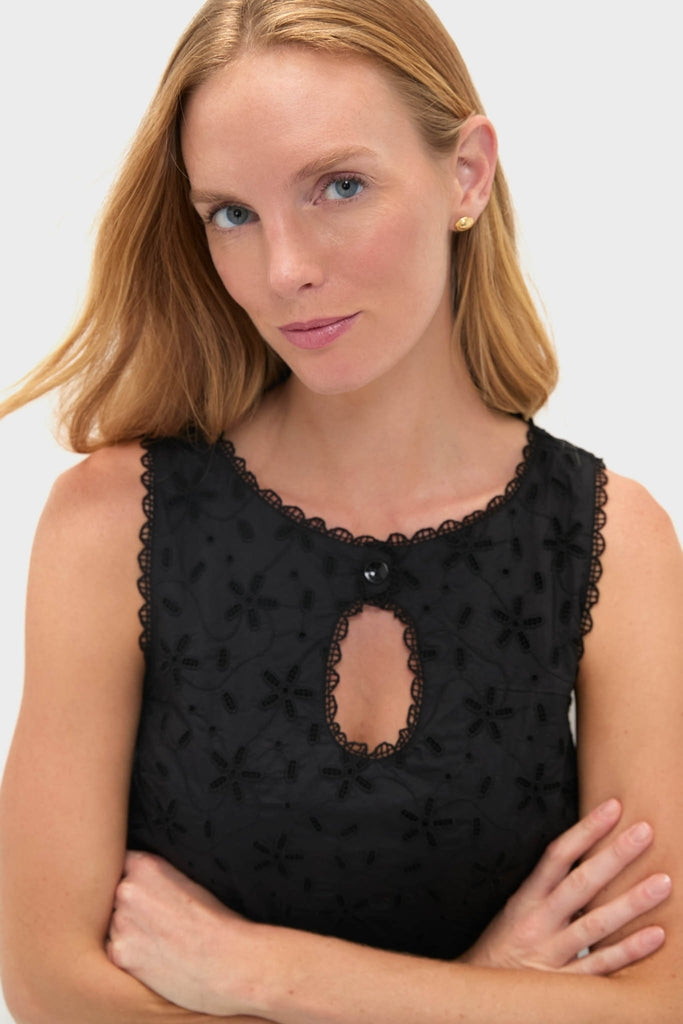 Woman in Black Salma Mini Dress, showcasing classic scalloped lace and eyelet details. The dress embodies effortless, high-end style, aligning with Tuckernuck's fun, confident ethos.