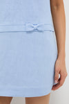 Blue Harper Mini Dress showcases a classic, light-blue linen-like material with an effortless style, featuring a matching belt with a bow. Fun, high-end fashion for any occasion.