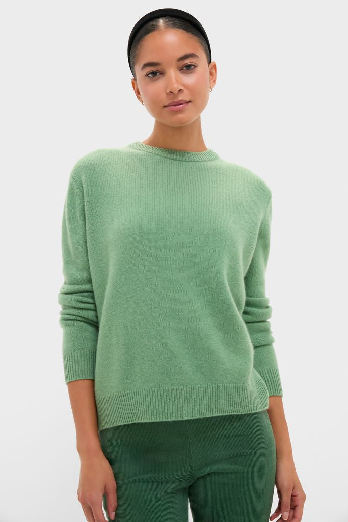 Model wearing the Meadow Green Cashmere Boyfriend Bodie Crewneck Sweater, showcasing its classic, effortless style paired with corduroy pants for a fun, high-end look.