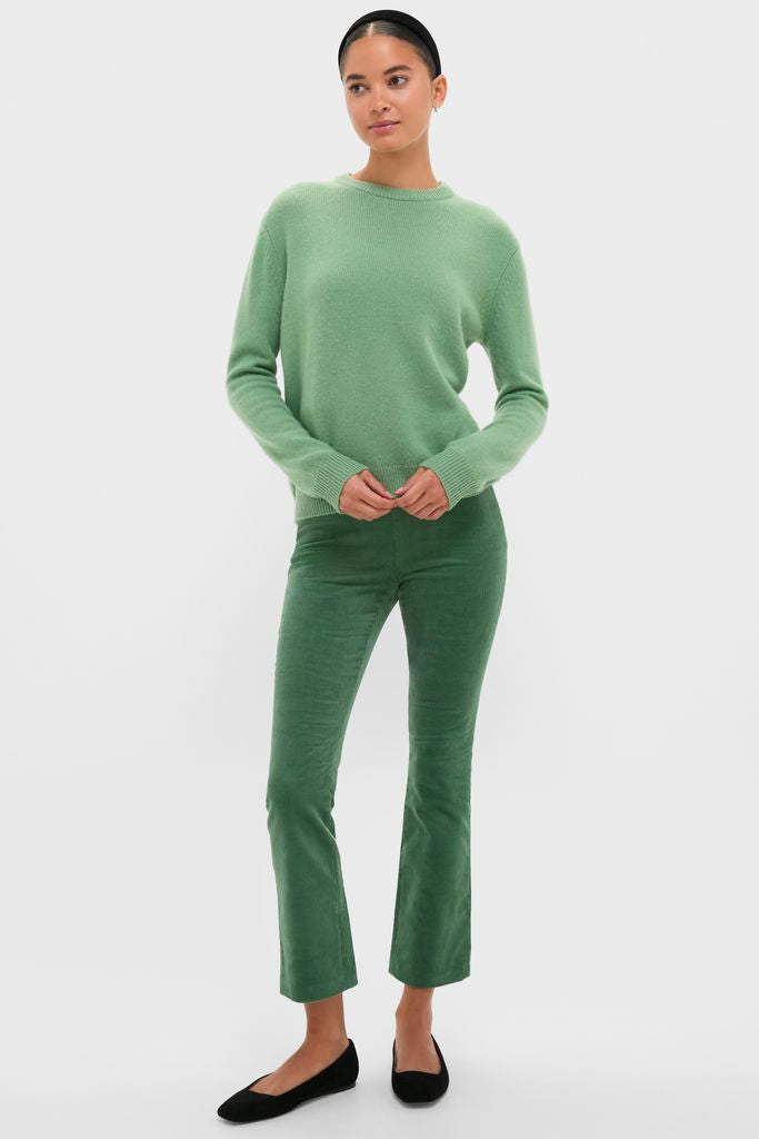 Woman wearing Meadow Green Cashmere Boyfriend Bodie Crewneck Sweater with flared corduroy pants and ballet flats, exuding a classic, effortless, and high-end style.
