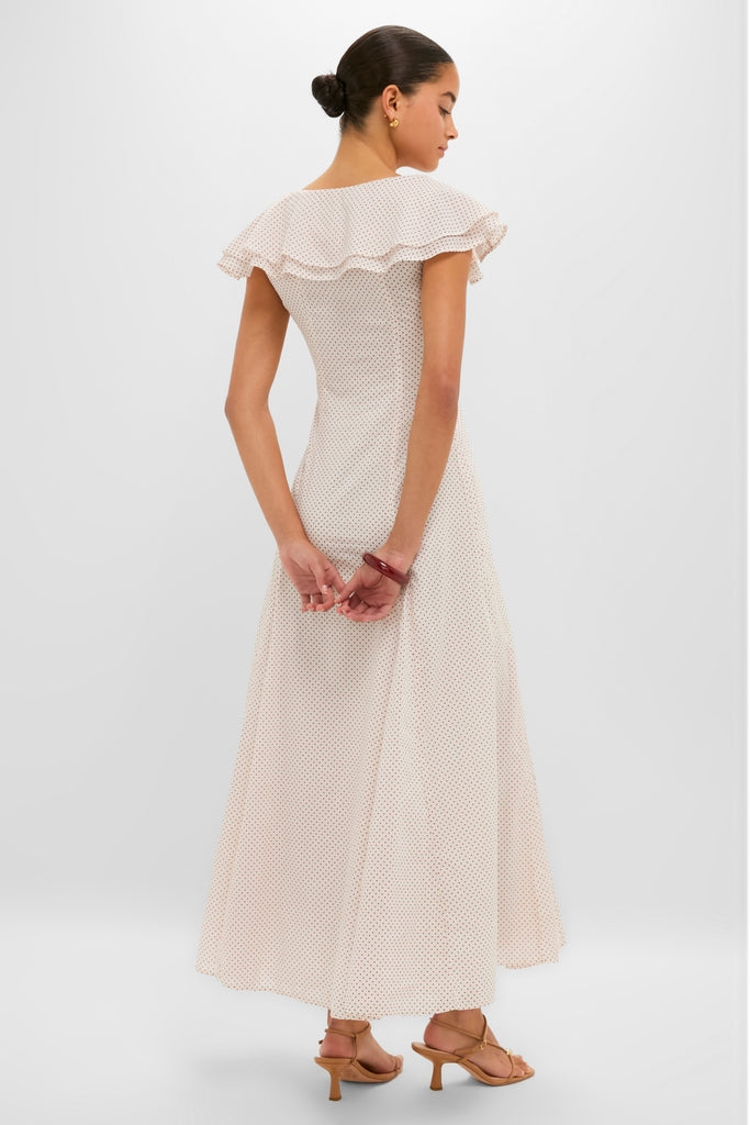 Young woman in a classic, high-end Cream and Red Polka Dot Marlowe Flutter Dress, exuding effortless style with ruffled collar and elegant accessories, embodying fun sophistication.