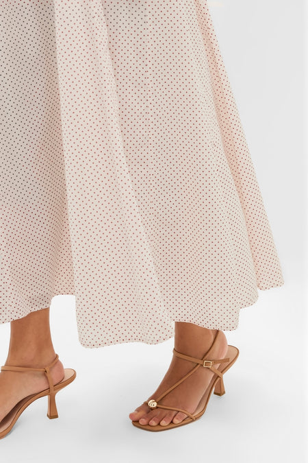 Cream and Red Polka Dot Marlowe Flutter Dress with a classic full skirt, paired with effortless, strappy nude-tan heeled sandals; embodies fun and high-end style.