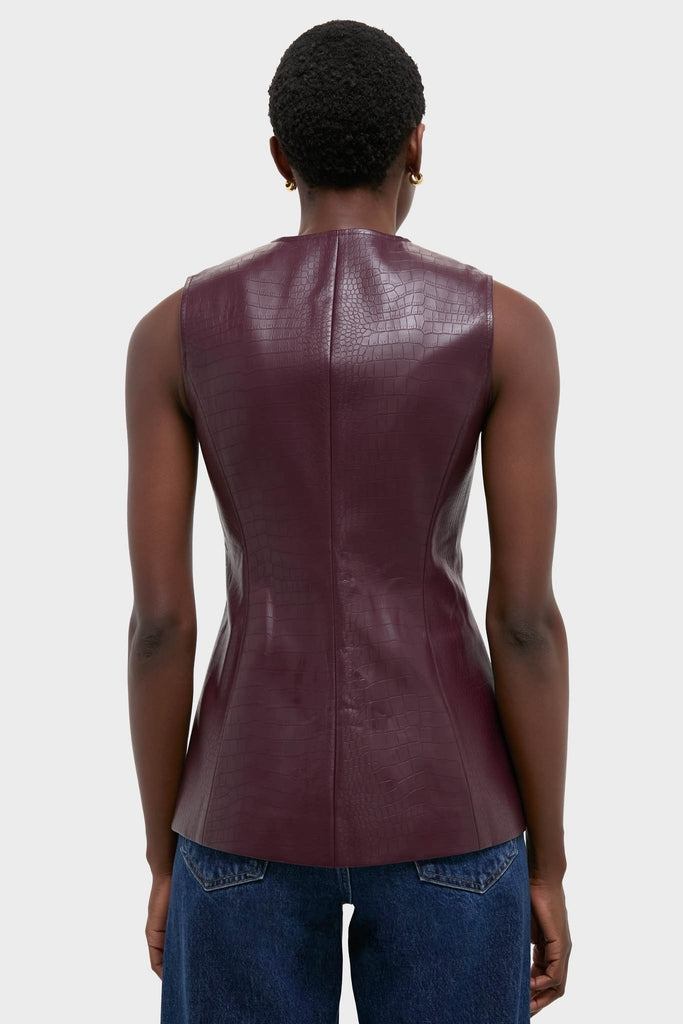 Back view of a person wearing the Plum Stamped Faux Leather Duke Top, showcasing its classic, effortless silhouette and croc-embossed texture, paired with medium-wash jeans for a high-end, fun look.
