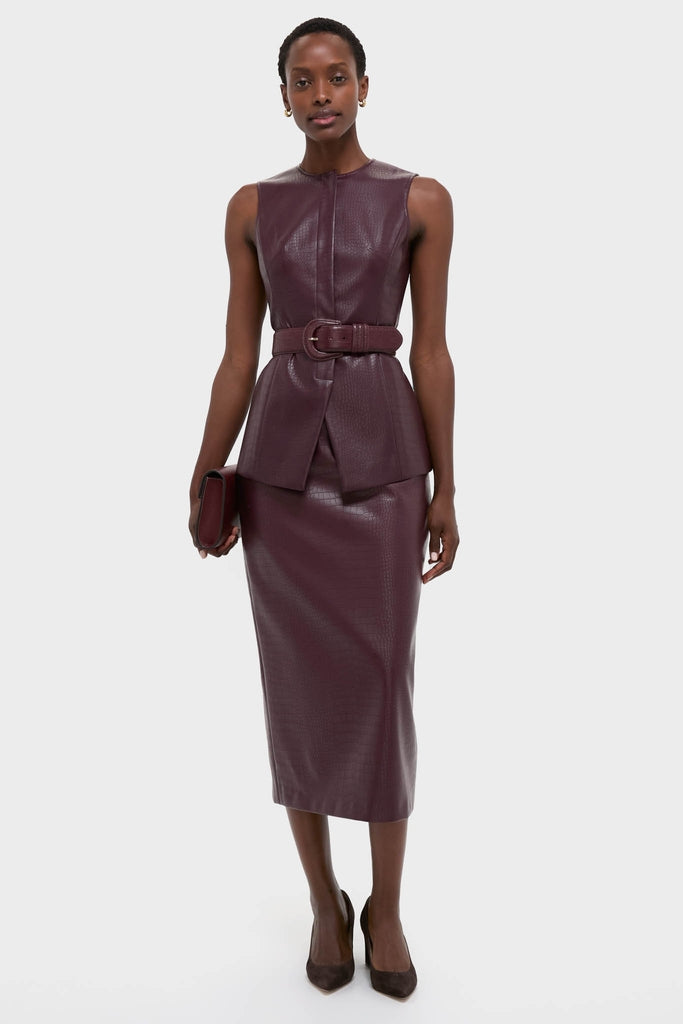 Model in a classic, high-end Plum Stamped Faux Leather Duke Top with a zip-front and belt, paired with a matching skirt for an effortless, fun look.