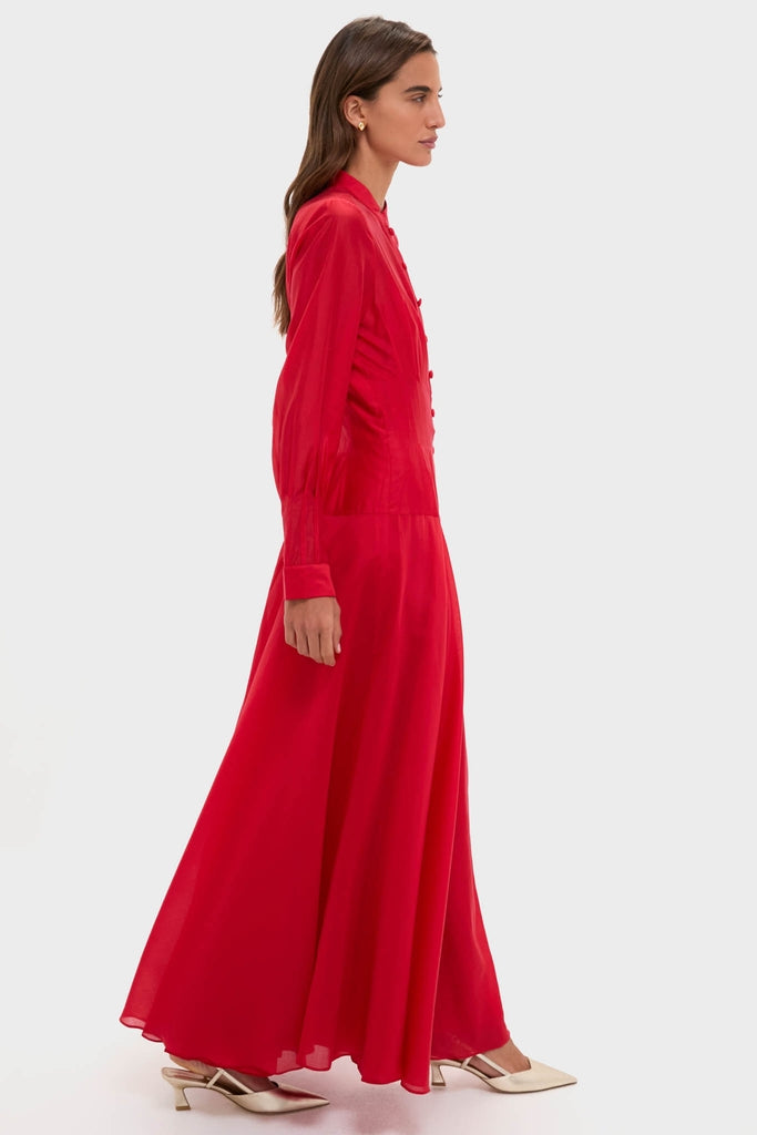 Woman in profile wears the classic and effortless Red Organza Marbella Dress, featuring a button-front and blouson sleeves, perfect for a fun and high-end occasion.