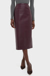 Model wearing the classic Plum Stamped Faux Leather Ellington Skirt, a high-end, effortless burgundy pencil skirt with croc-embossed texture, paired with grey top and suede pumps.