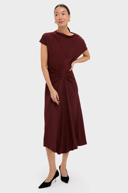 Black Cherry Dena Midi Dress exudes classic elegance with its draped neckline, ruched waist, and asymmetrical hem, paired effortlessly with black heels for a fun, high-end look.