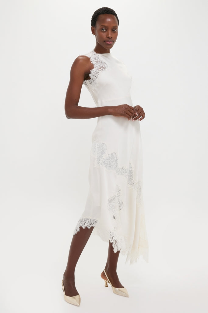 Model wearing the classic Creme Satin Lace Alessia Midi Dress with lace panels and asymmetric hem, paired with metallic heels for an effortless, high-end look.
