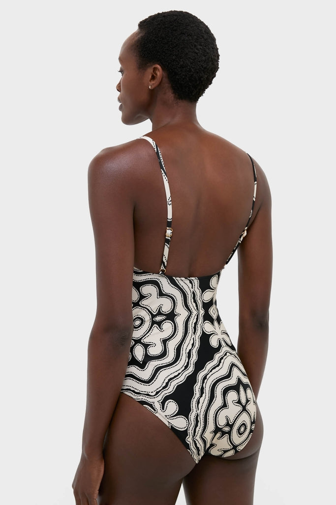 Rear view of person in Niku Black Elene One Piece, showcasing its classic, high-cut design with adjustable straps and abstract pattern. Effortless, high-end swimwear for fun, confident style.
