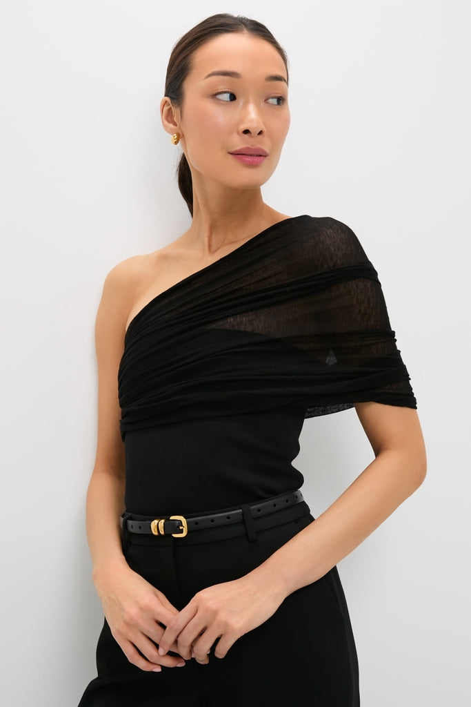 Woman wearing the Black Satterly Top, an effortlessly classic one-shoulder piece, paired with high-waisted trousers, embodying a fun, high-end style at Tuckernuck.