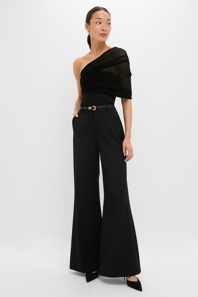 Model in a classic Black Satterly Top, featuring a one-shoulder, semi-sheer design, paired with effortless high-waisted trousers, embodying Tuckernuck's high-end, fun style.