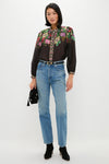Model showcases a classic, effortless look with a Black Hip to Waist Skinny Belt, paired with a floral blouse and jeans, embodying Tuckernuck's fun, high-end style.