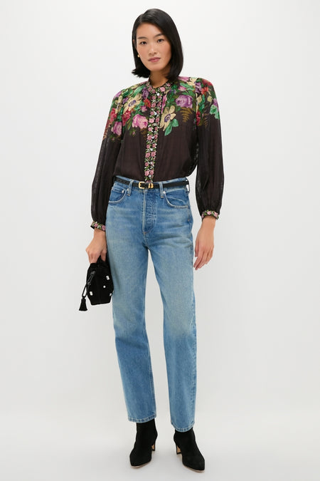 Model showcases a classic, effortless look with a Black Hip to Waist Skinny Belt, paired with a floral blouse and jeans, embodying Tuckernuck's fun, high-end style.