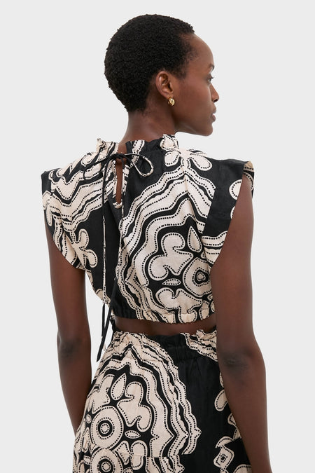 Woman in Niku Black Muna Ruched Crop Top with abstract dot print, featuring a ruched neckline and back tie, embodying classic, effortless style.