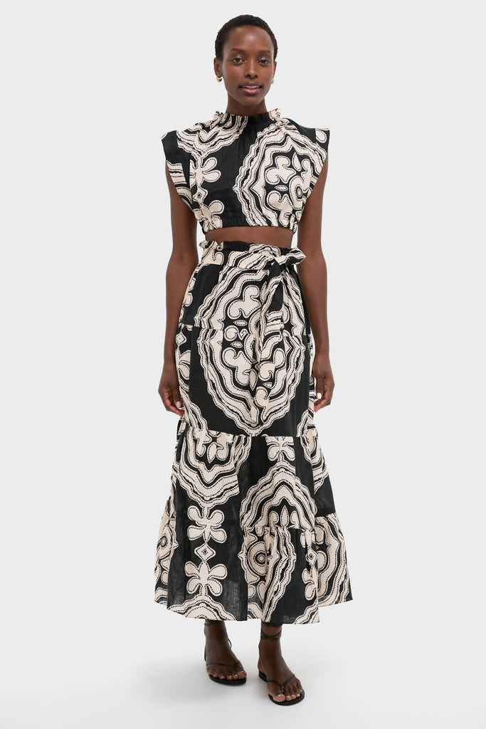 Woman in Niku Black Muna Ruched Crop Top and Sanaa Skirt, showcasing an effortless, high-end style with classic architectural-inspired print, embodying Tuckernuck's fun, confident ethos.