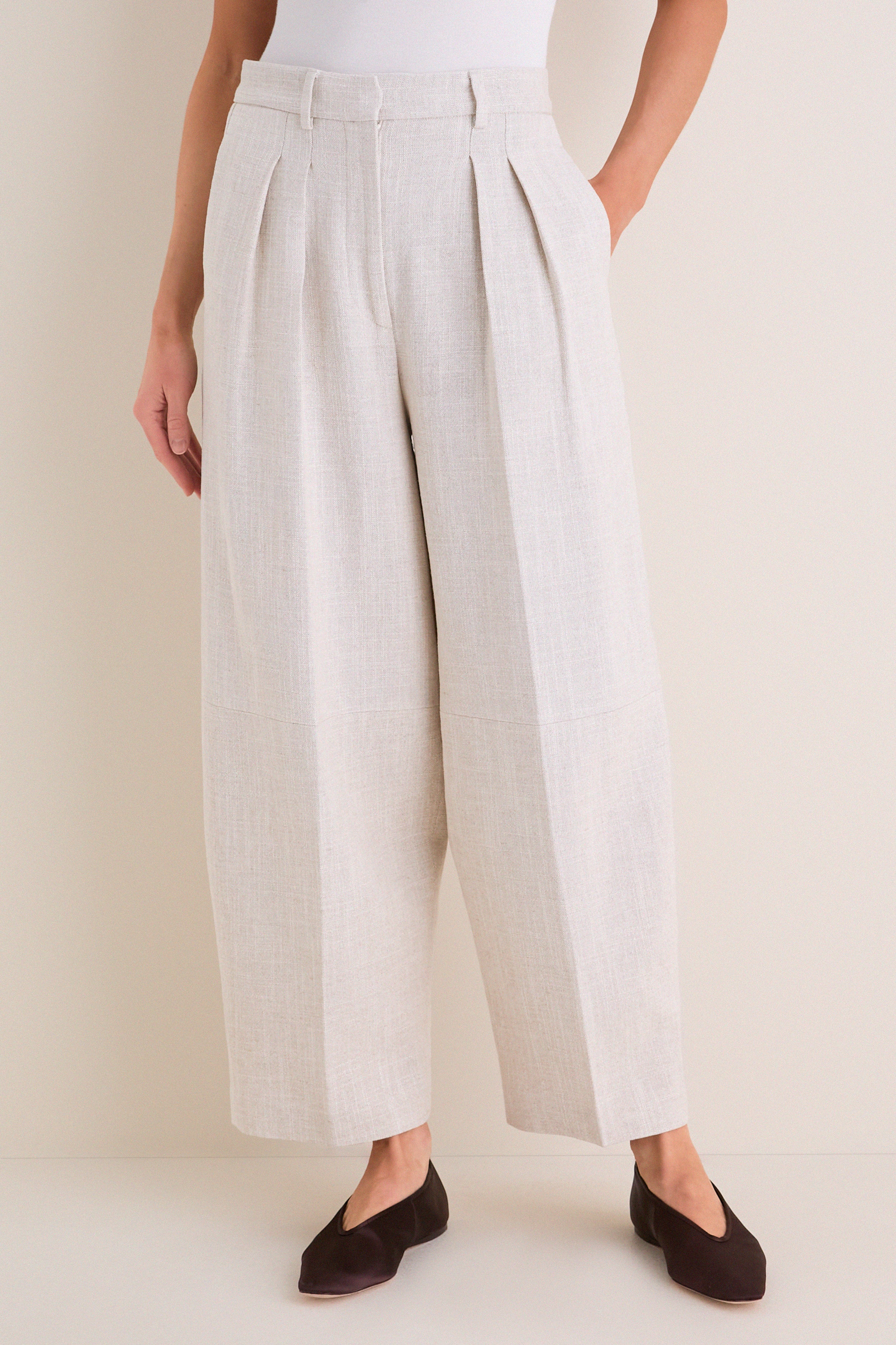 Model wearing Mortar Melange Dash Pants, classic wide-leg culottes with pleats and cropped barrel-leg design, paired with flats for an effortless, high-end look.