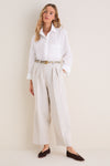 Model in classic Mortar Melange Dash Pants, showcasing an effortless, high-end look with pleated, barrel-leg style, paired with a white shirt and chic accessories.