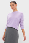 Woman wearing a classic Lavender Frost Cashmere Boyfriend Bodie Crewneck Sweater paired with a grey skirt, embodying an effortless, high-end style.