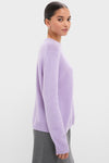 Young woman models the classic Lavender Frost Cashmere Boyfriend Bodie Crewneck Sweater, showcasing its effortless, high-end style with ribbed cuffs and hem, epitomizing Tuckernuck's fun, confident fashion.