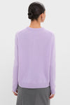 Person in a sleek low bun wears the Lavender Frost Cashmere Boyfriend Bodie Crewneck Sweater, showcasing its classic, effortless design with ribbed hem and center seam detail.