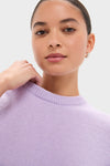 Young woman wearing the classic Lavender Frost Cashmere Boyfriend Bodie Crewneck Sweater, highlighting its effortless, high-end knit design. Perfect for a fun, confident look.