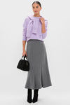 Woman wearing a classic Lavender Frost Cashmere Boyfriend Bodie Crewneck Sweater, paired effortlessly with a gray midi skirt, black suede ankle-boots, and a high-end black handbag.