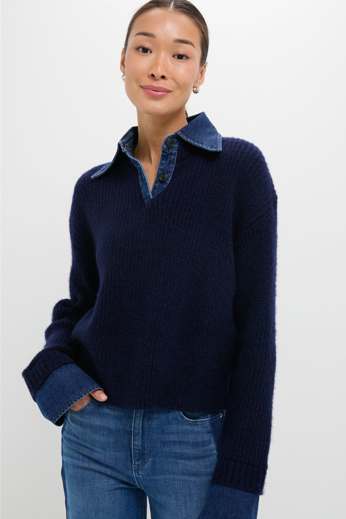 Model wearing the classic Navy and Denim Harvey Sweater with effortless fit, featuring denim collar and cuffs, over jeans, embodying Tuckernuck's fun, high-end style.