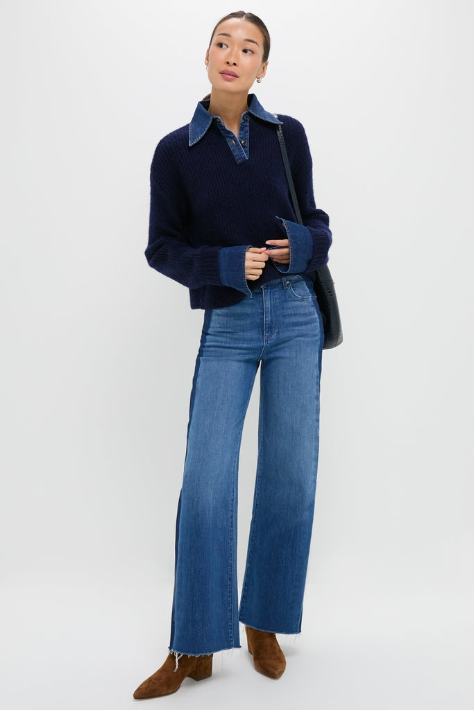 Person wearing the classic Navy and Denim Harvey Sweater layered over a denim-collared shirt, paired with wide-leg jeans and brown suede boots, exuding an effortless, high-end style.