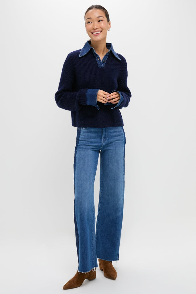 Young woman models the Navy and Denim Harvey Sweater, showcasing its classic, effortless style with denim collar and cuffs, paired with high-waisted jeans and brown ankle boots.