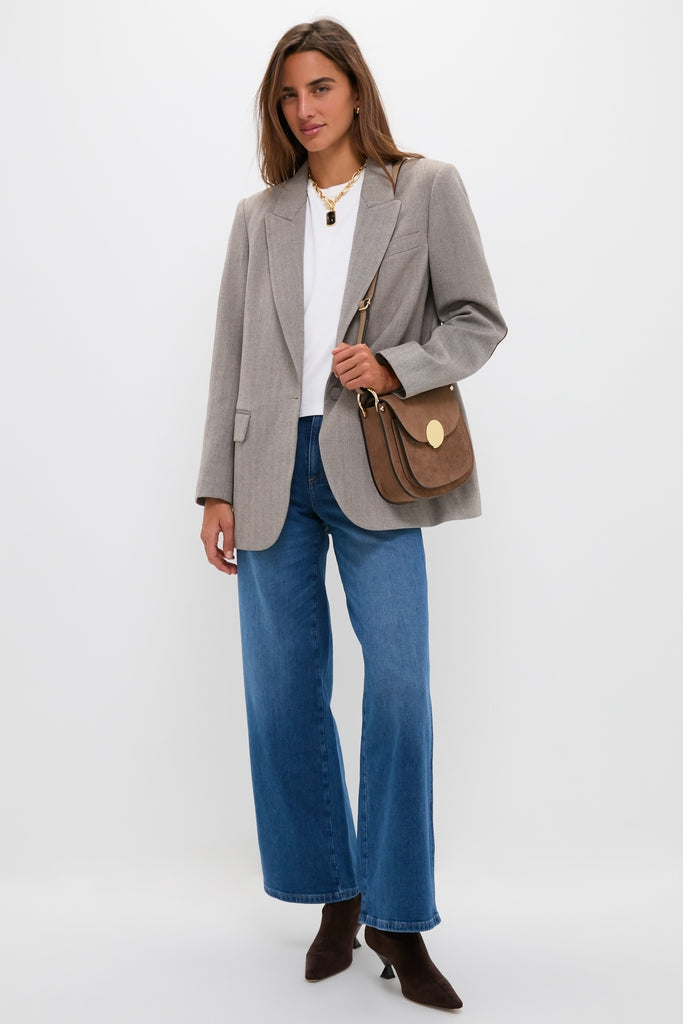 Model wearing the London Calling Juliette High Rise Wideleg jeans, styled effortlessly with a light-gray blazer, white T-shirt, and chic brown suede accessories for a classic, high-end look.