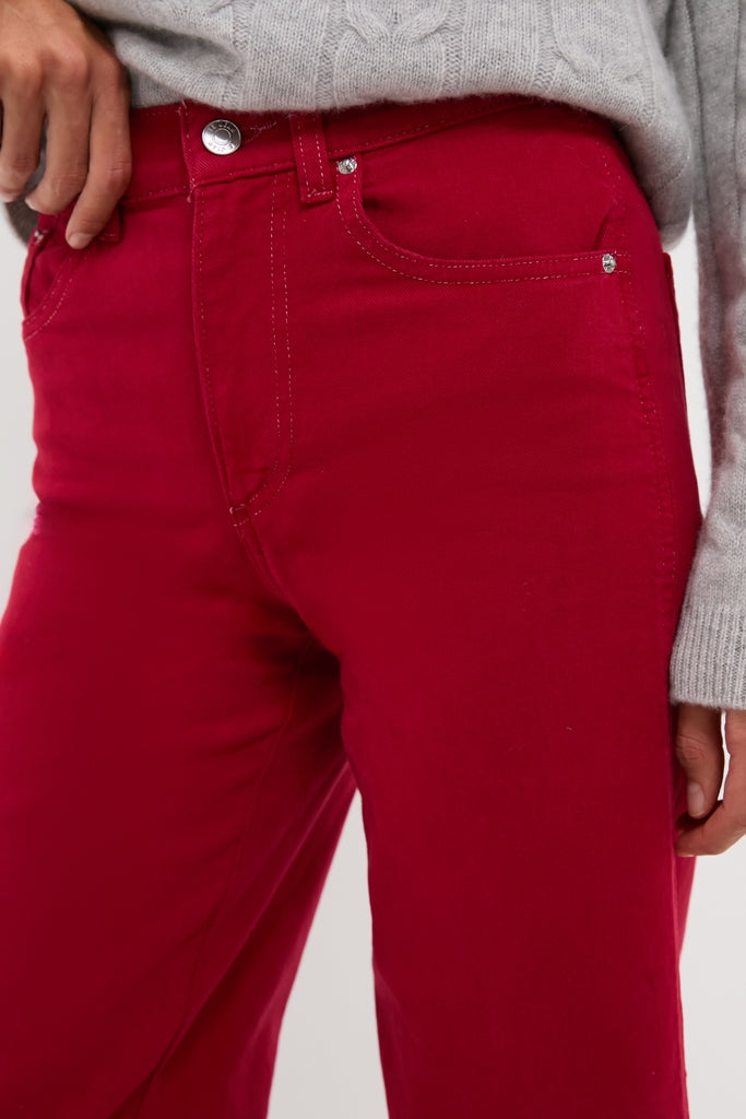 Red Juliette High Rise Wideleg Ankle jeans in bright red, featuring a classic high-rise waist and fitted hips, paired with a light gray knit sweater for an effortless, high-end look.