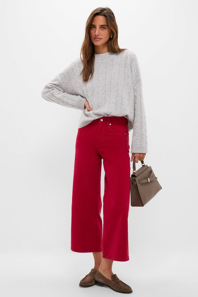 Woman in light gray sweater and standout Red Juliette High Rise Wideleg Ankle pants, styled effortlessly with loafers and a taupe handbag, exuding classic, high-end fashion.