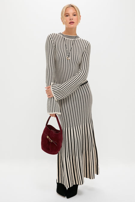 Woman models classic, effortlessly chic ribbed knit dress. She wears the Mixed Lucy Williams Entwine Pendant Cord Necklace, adding a fun, high-end touch.
