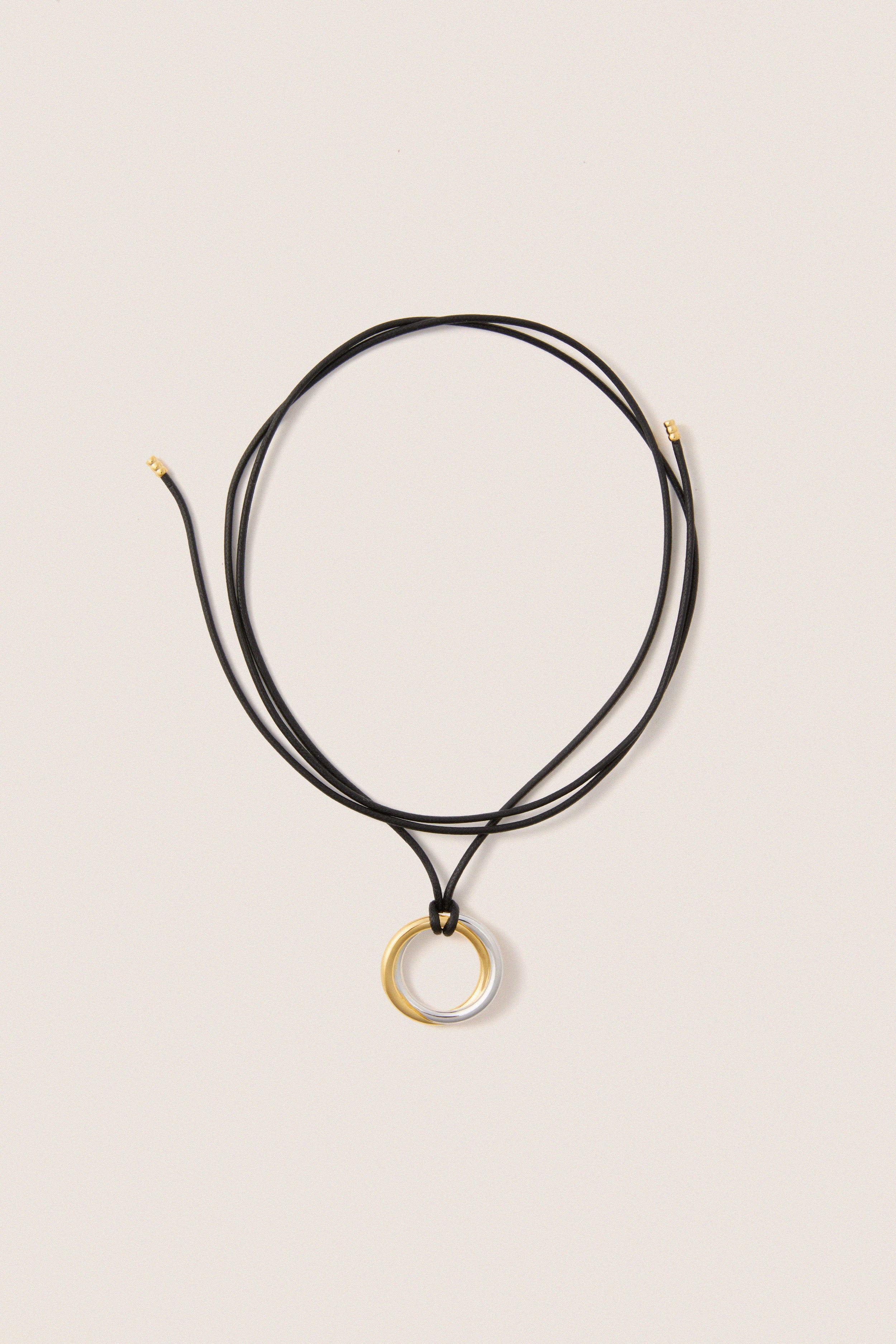 Mixed Lucy Williams Entwine Pendant Cord Necklace features a classic, effortless design with two-tone rings on an adjustable black cord, offering a fun, high-end look.