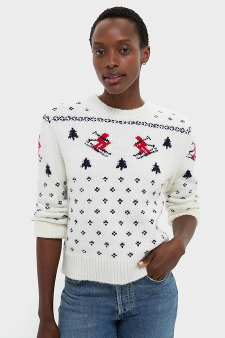 Person wearing the Ski Lodge Crew Sweater, featuring classic alpine motifs with skiers, paired with blue jeans. Effortlessly fun and high-end for winter days.