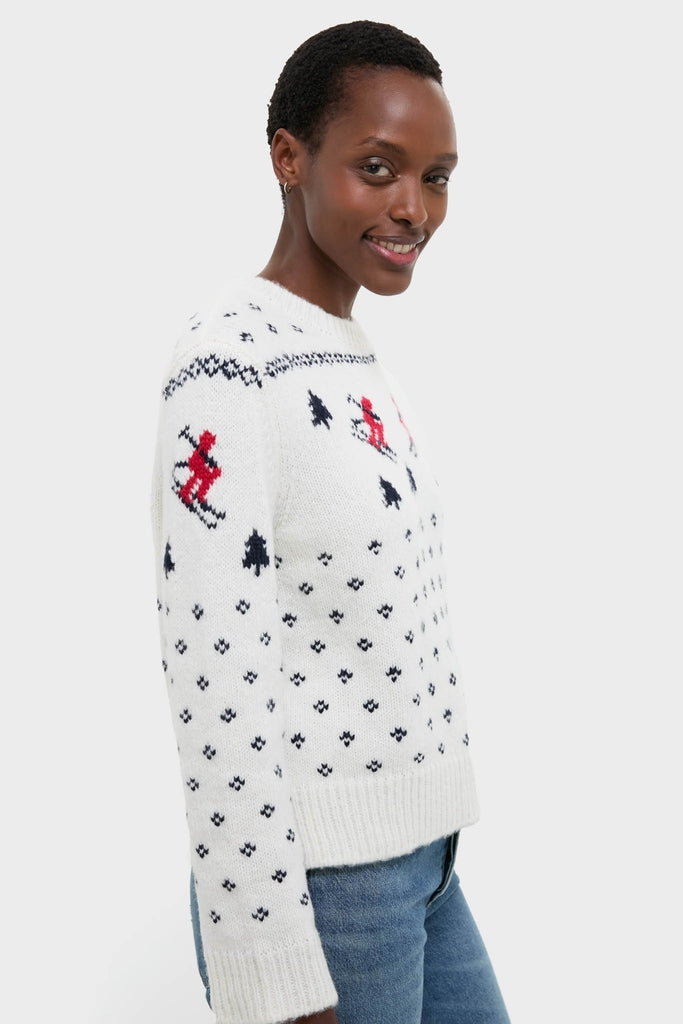 Person modeling the Ski Lodge Crew Sweater, featuring classic alpine motifs and skiers, paired effortlessly with jeans for a fun, high-end, and cozy winter look.
