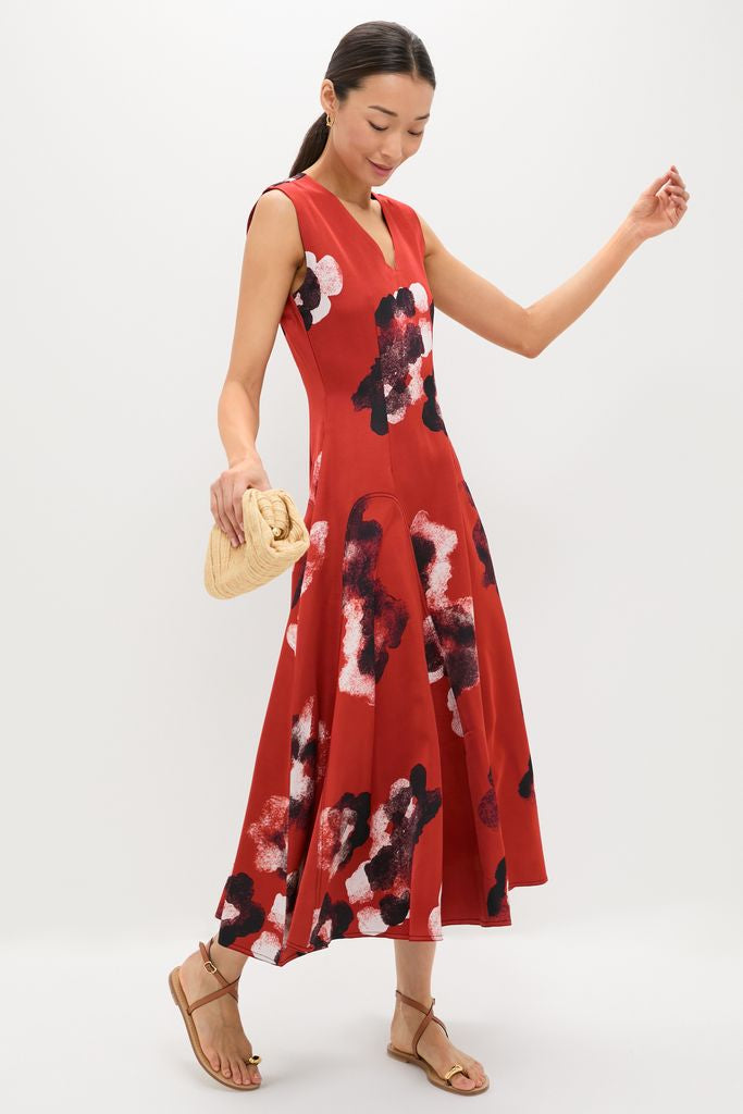 Woman in a classic Crimson Red Water Floral Cosmic Midi Dress, showcasing an effortless fit-and-flare design with a woven clutch and sandals, exuding high-end, fun style.